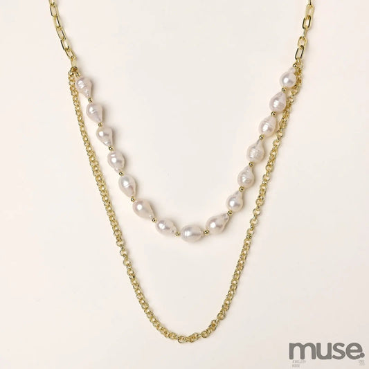 Layered gold chain necklace with irregular freshwater pearls on cream background, showing adjustable dual-strand design.
