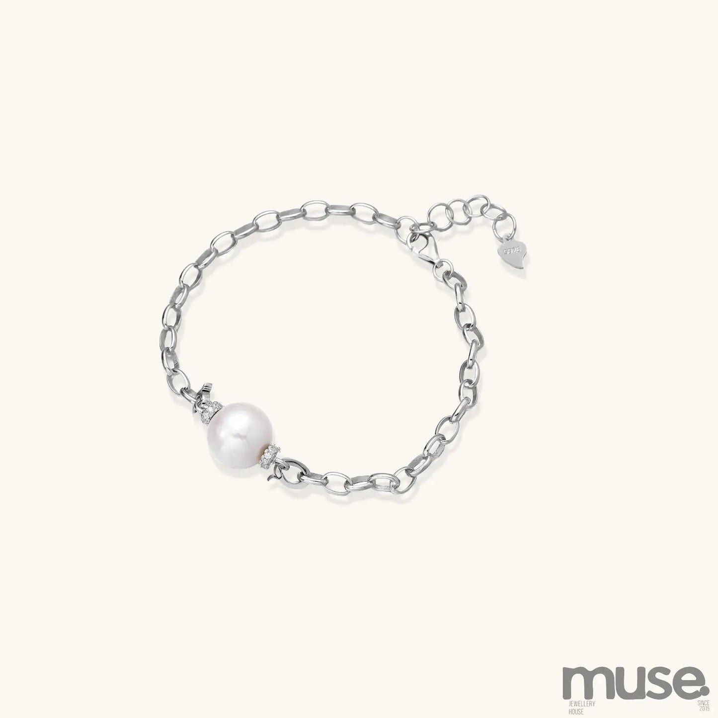 Dainty sterling silver chain bracelet with round freshwater pearl and crystal accents on white background.