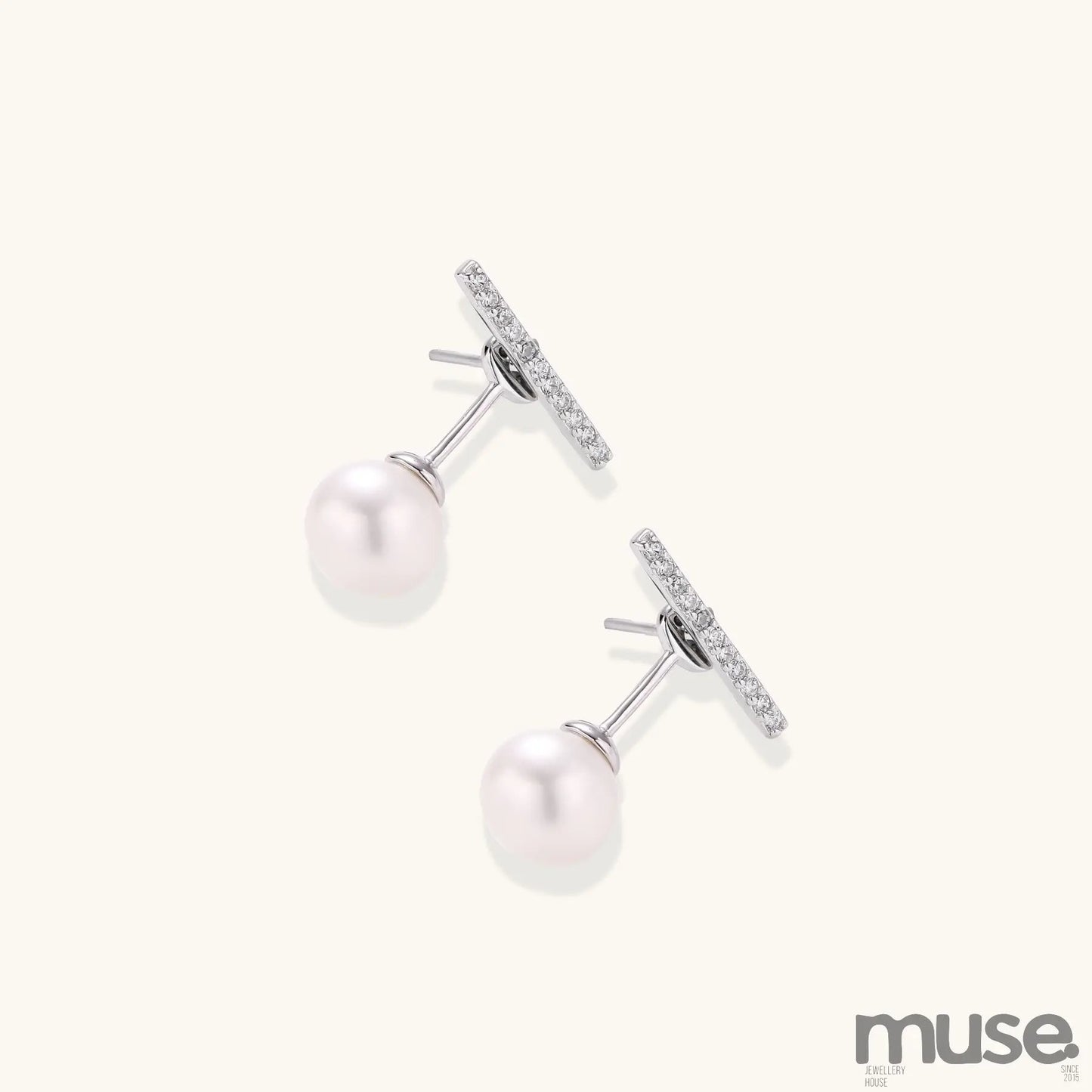 Sterling silver bar stud earrings with freshwater pearl drops on white background, minimalist jewelry design