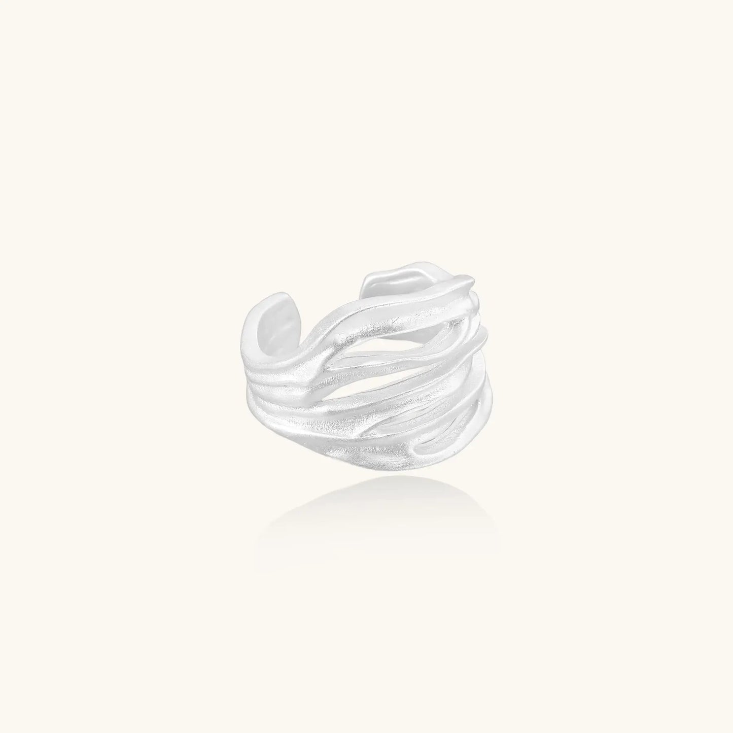 Wide sterling silver ring with flowing wave patterns and adjustable cuff design on white background.