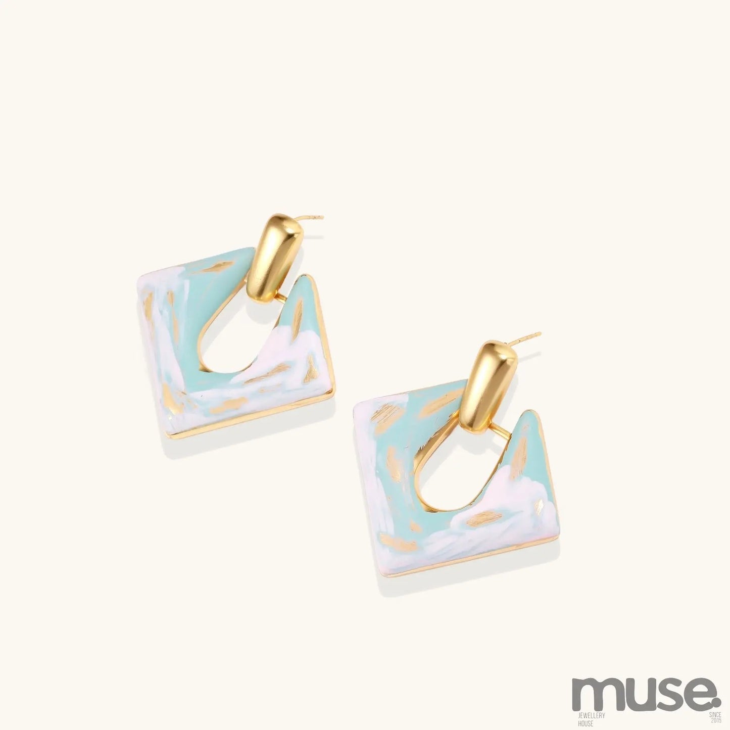 Diamond-shaped gold-plated earrings with pastel marble enamel in turquoise and lavender swirls on beige background