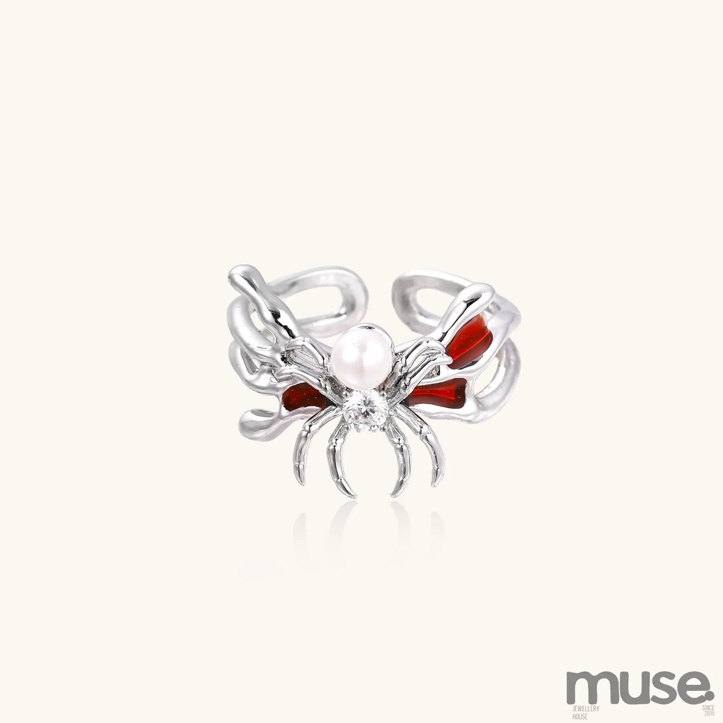 Gold-plated adjustable ring featuring spider design with white pearl, red enamel accents, and central zirconia stone