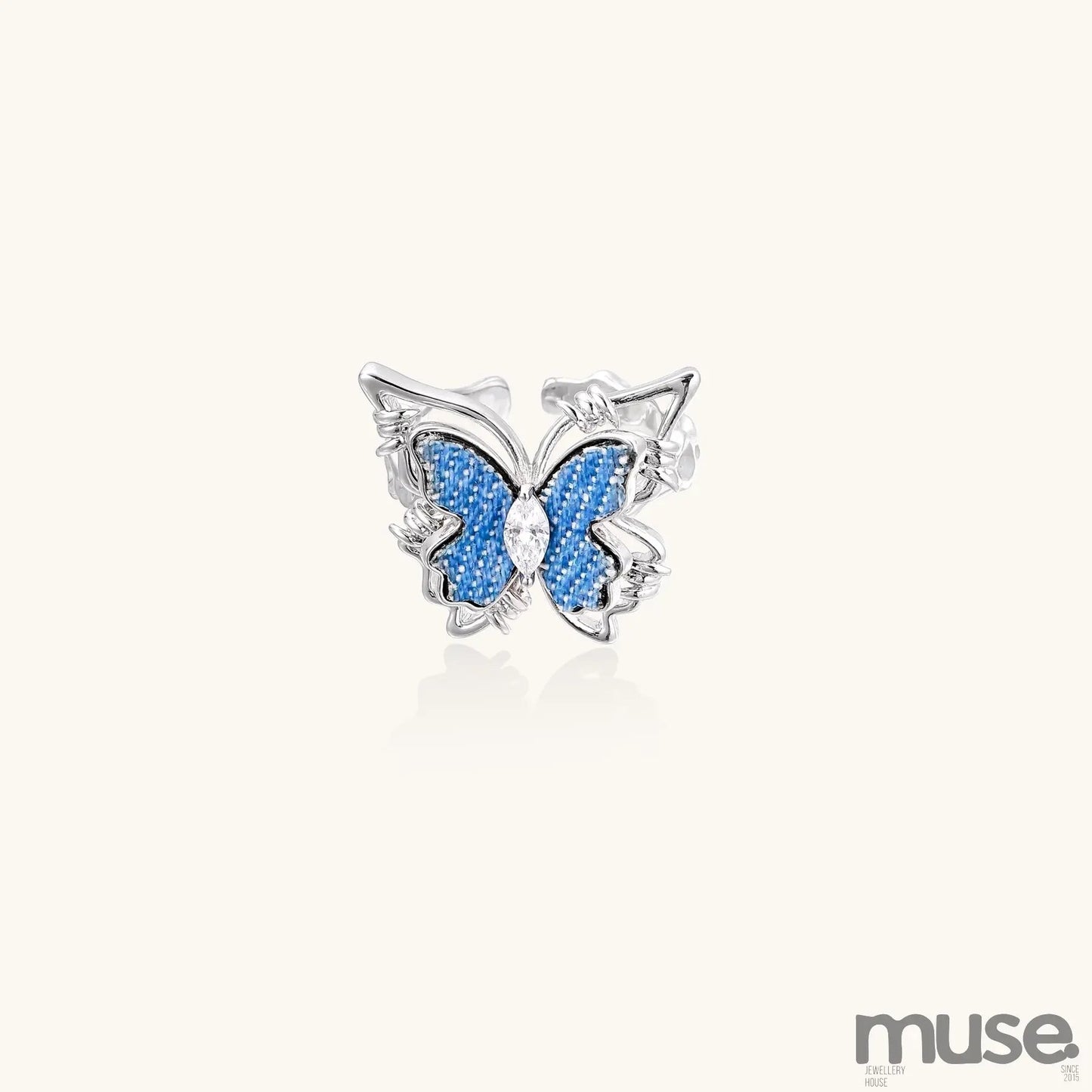 Gold-plated brass ring featuring blue butterfly design with central zirconia stone on neutral background.