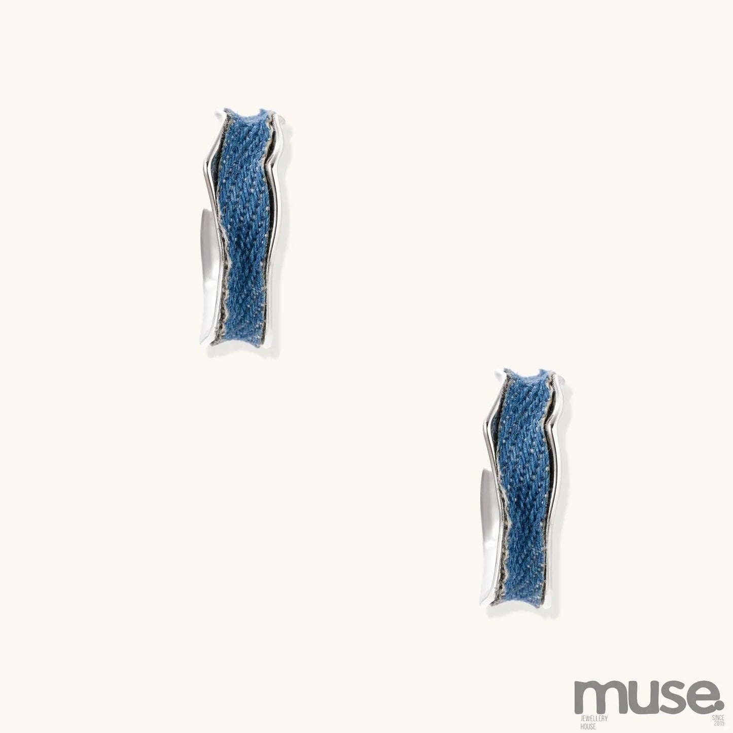 Small gold-plated hoop earrings with blue denim fabric insets on white background, showing casual-luxe styling.