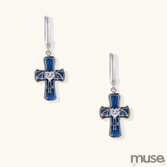 Gold-plated brass cross earrings with blue enamel, wing details, and heart-shaped zirconia stones on white background