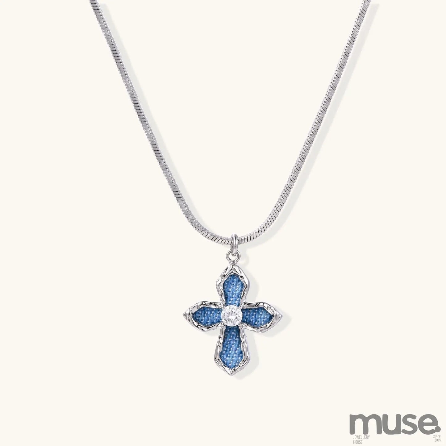 Gold-plated cross pendant with blue denim fabric insets and central zirconia stone on adjustable snake chain