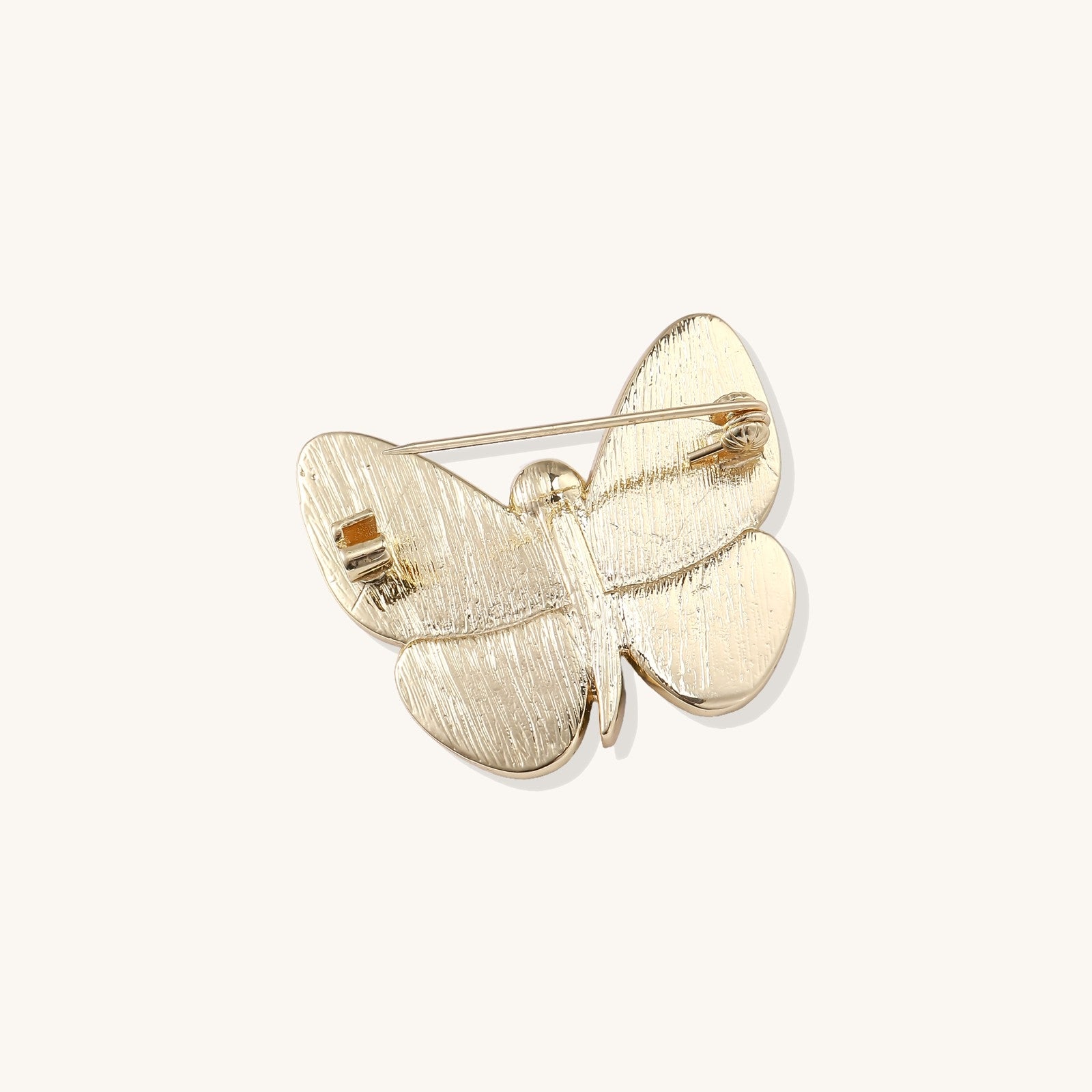 Iridescent abalone shell butterfly pin with central pearl and gold setting, showing rainbow color reflections