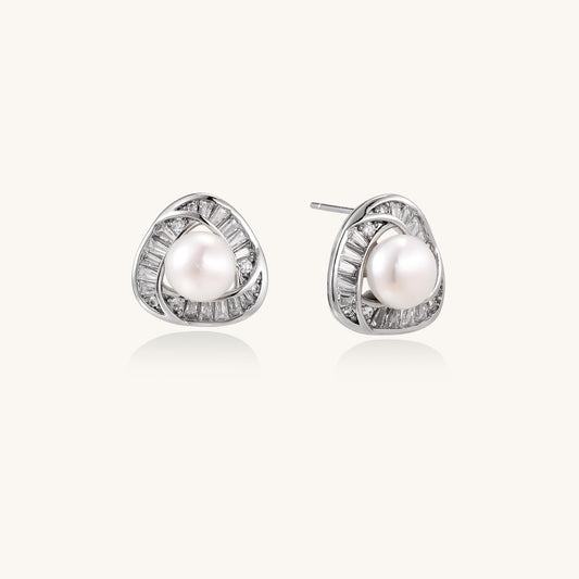 Close-up of triangular gold-plated stud earrings with central freshwater pearl surrounded by baguette crystals