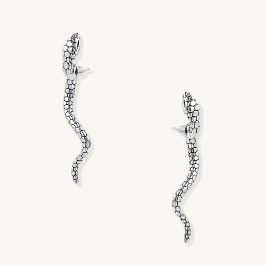 Pair of gold-plated brass snake drop earrings with detailed scale texture and curved serpentine design against white background