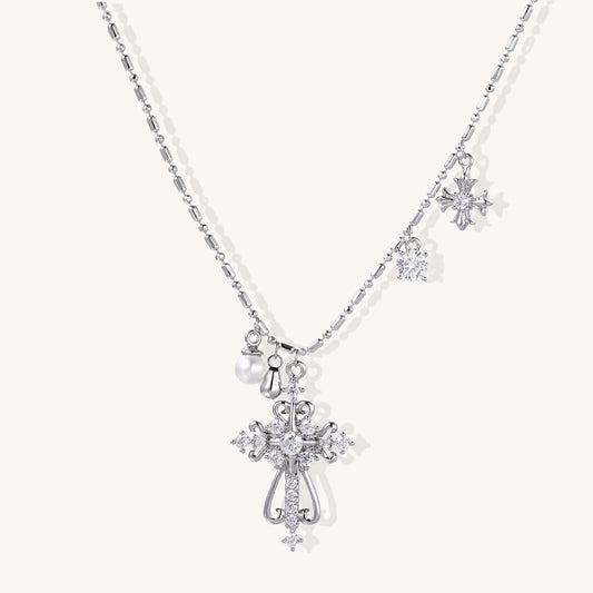 Layered gold-plated cross necklaces with baroque pearls and crystal embellishments on white background