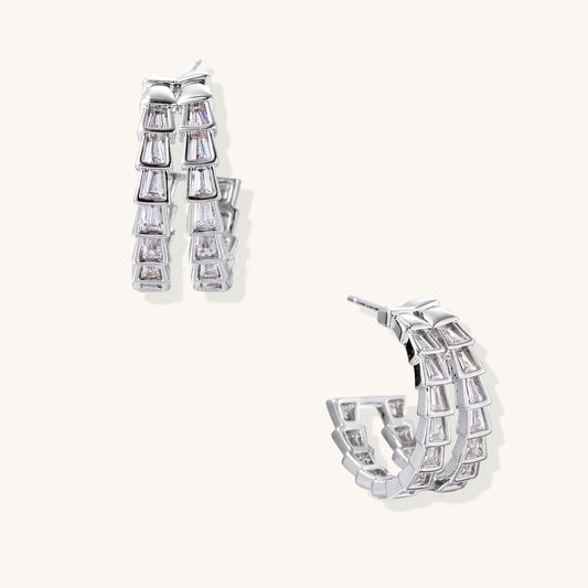 Gold-plated huggie hoops featuring vertical rows of clear baguette zirconia stones in geometric linear design