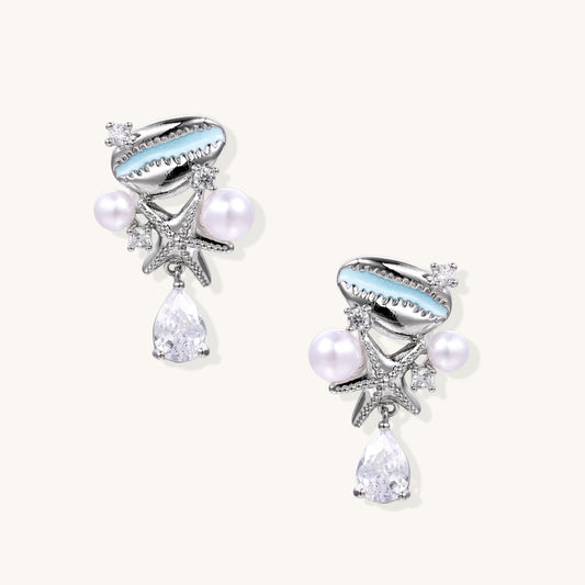 Gold-plated dangle earrings with enamel shell charms, white pearls, starfish accents, and crystal drops on white background.