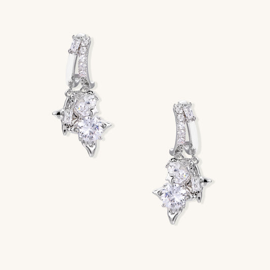 Pair of gold-plated drop earrings featuring cascading zirconia crystals in geometric cluster design on neutral background