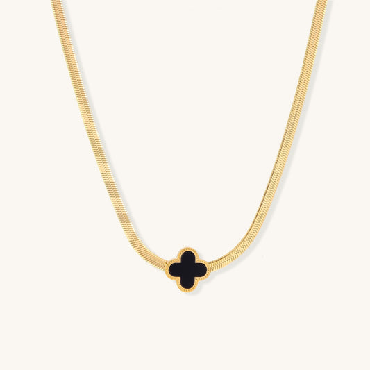 Delicate gold-plated chain necklace featuring a black quatrefoil clover pendant on white background.