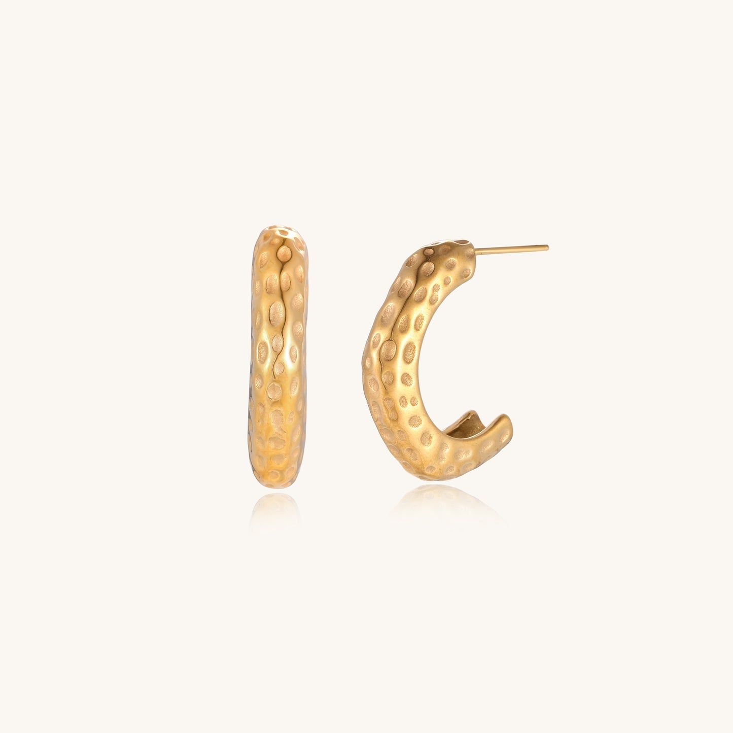 Textured gold-plated hoop earrings with dimpled surface pattern and post backs on neutral background.