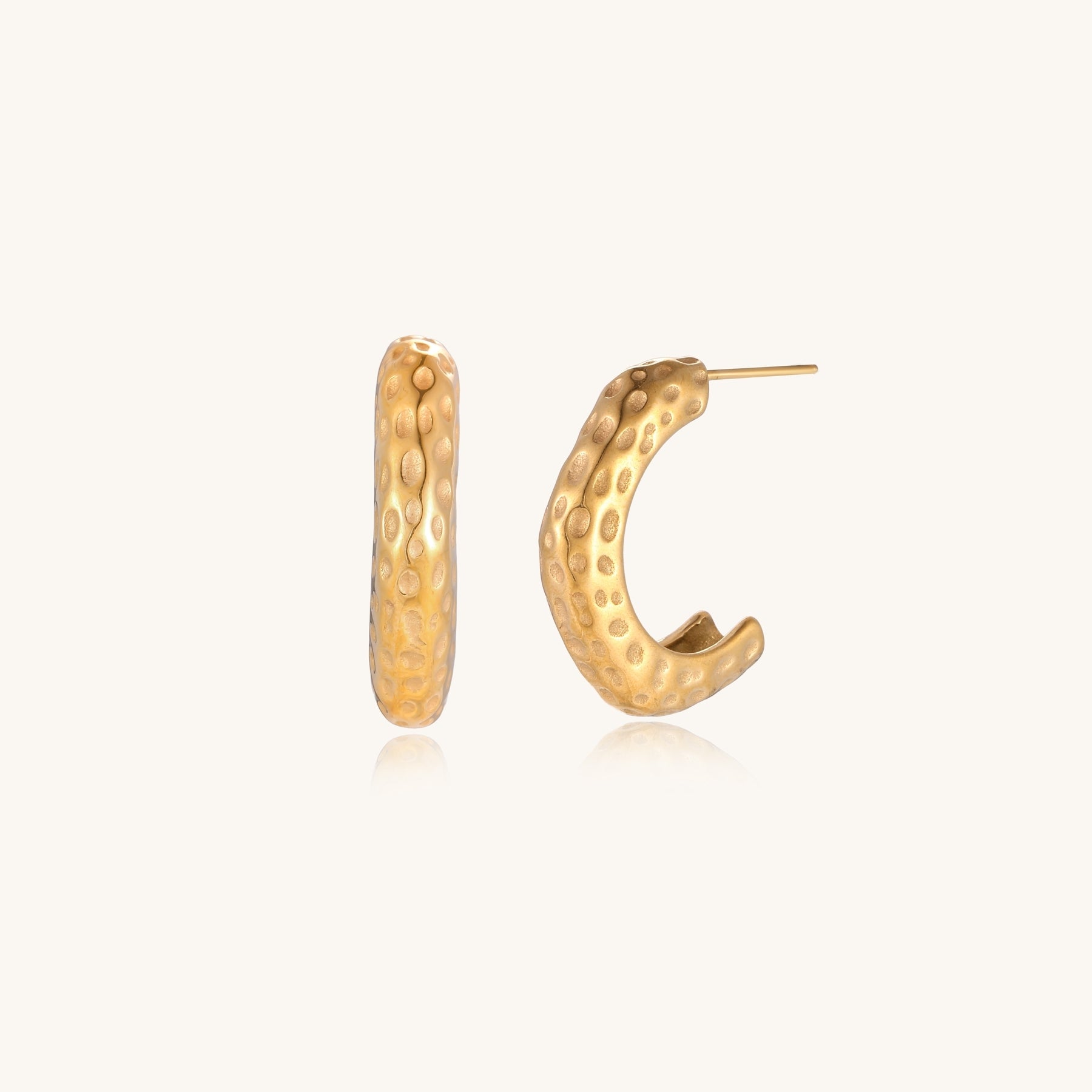 Textured gold-plated hoop earrings with dimpled surface pattern and post backs on neutral background.