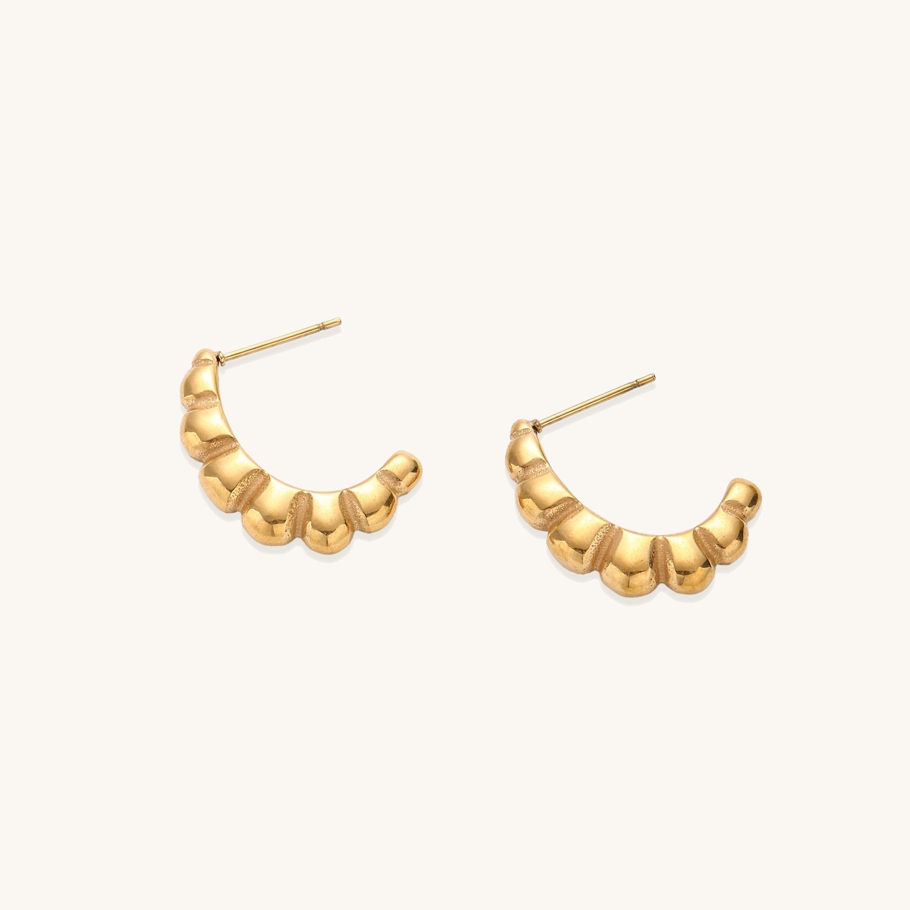 Gold-plated stainless steel hoop earrings with segmented bubble design and post closure on white background